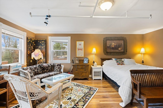 bedroom featuring light wood-type flooring and crown molding