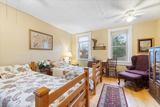 bedroom featuring light wood-type flooring, rail lighting, and ceiling fan