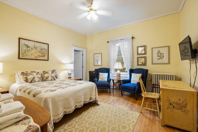 bedroom with light wood-type flooring, ceiling fan, and crown molding