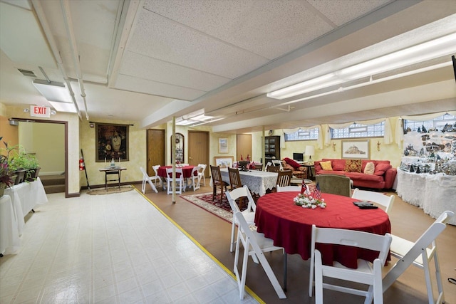 dining area featuring a drop ceiling