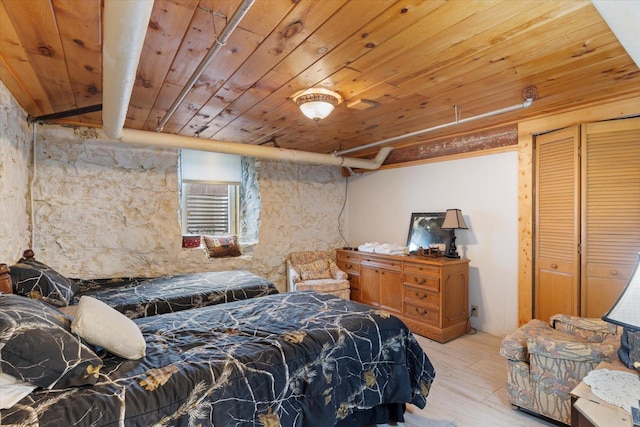 bedroom with light hardwood / wood-style flooring, a closet, and wood ceiling