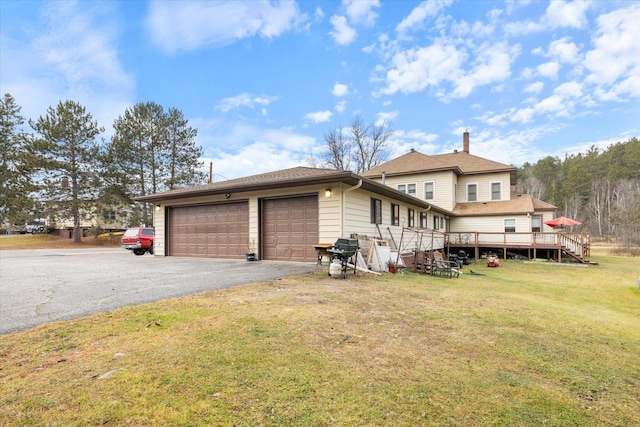 exterior space with a garage, a front yard, and a deck