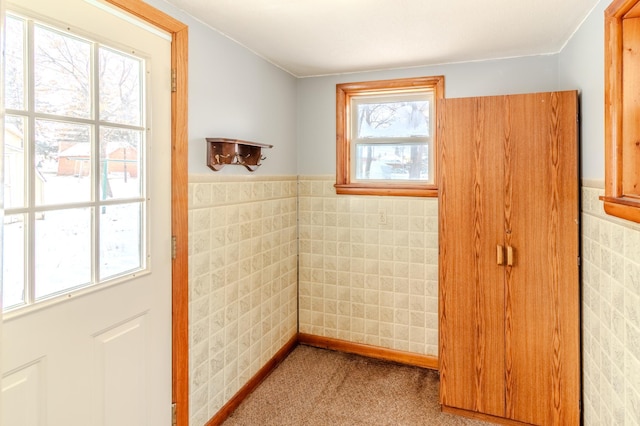 doorway with carpet and tile walls