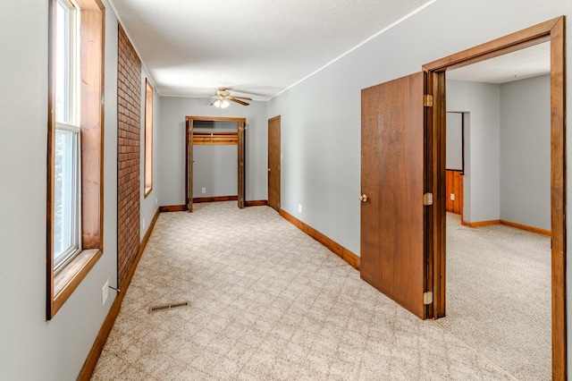 hall featuring light carpet and a textured ceiling