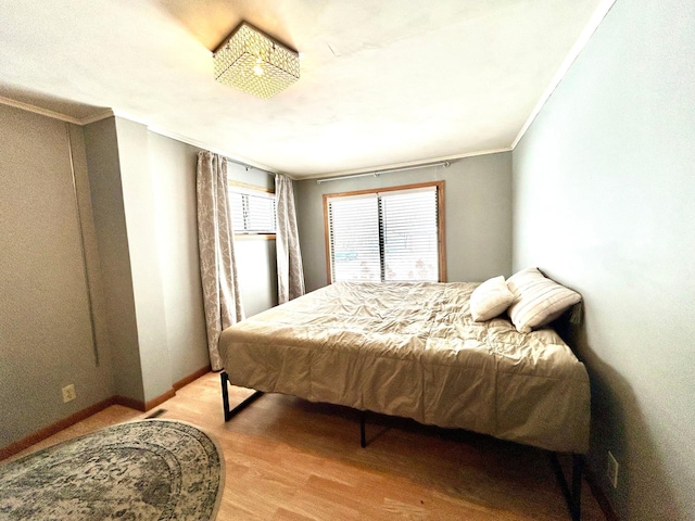 bedroom with ornamental molding and light hardwood / wood-style flooring