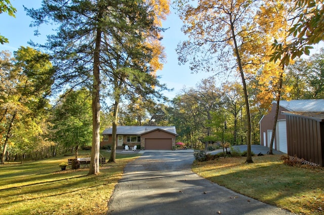 ranch-style house featuring aphalt driveway, a front lawn, and a garage