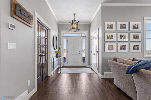 entrance foyer featuring crown molding, dark hardwood / wood-style floors, and an inviting chandelier