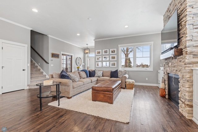 living room featuring a stone fireplace, dark hardwood / wood-style flooring, and ornamental molding