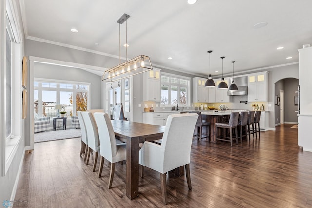 dining space featuring crown molding, dark hardwood / wood-style flooring, and sink