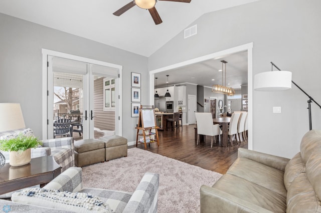 living room featuring ceiling fan, dark wood-type flooring, and vaulted ceiling