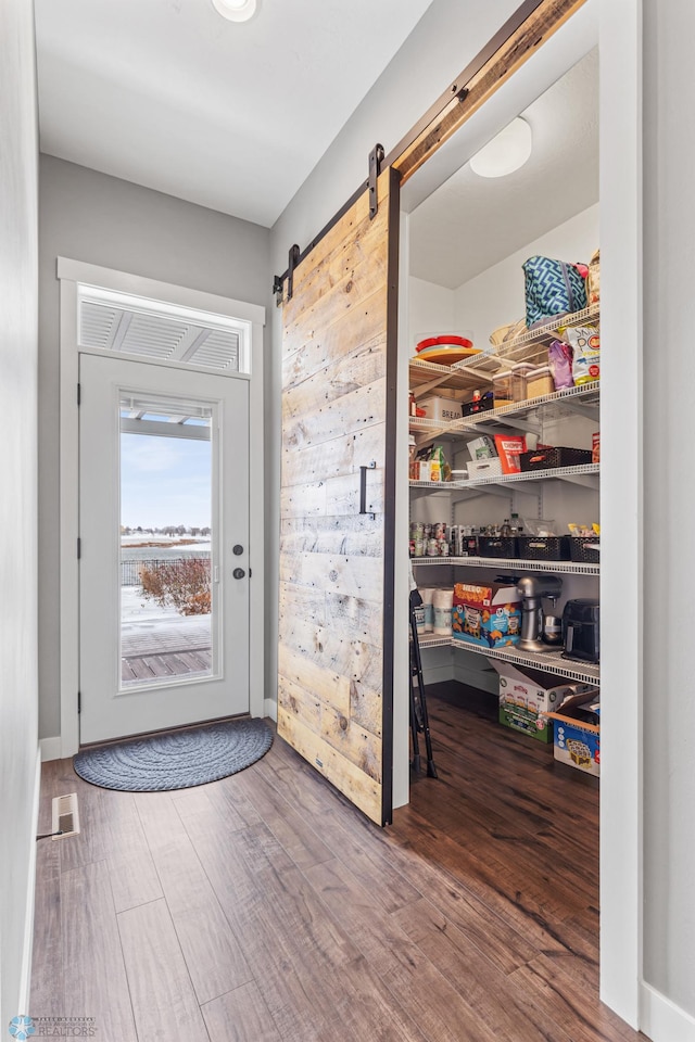 entryway featuring a barn door and hardwood / wood-style flooring