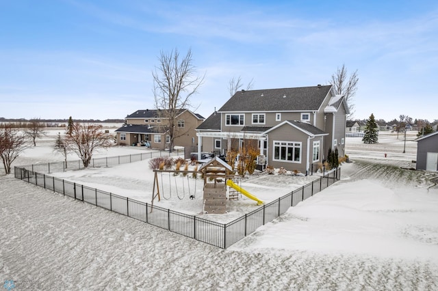 snow covered house featuring a playground