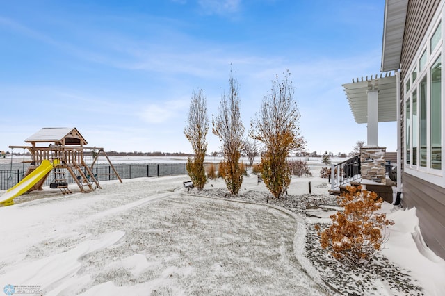 yard layered in snow with a playground