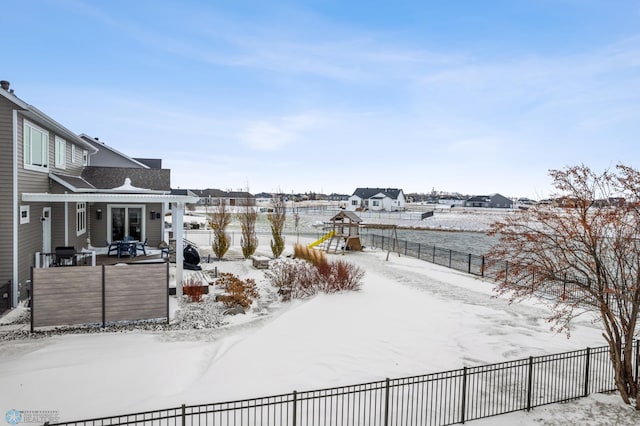 snowy yard featuring a playground