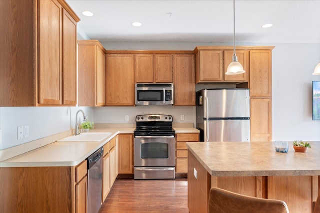 kitchen featuring sink, dark hardwood / wood-style flooring, stainless steel appliances, and hanging light fixtures