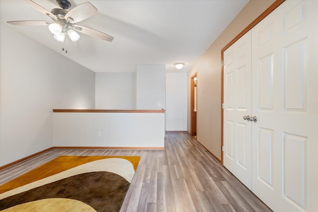 hall with a textured ceiling and light hardwood / wood-style floors