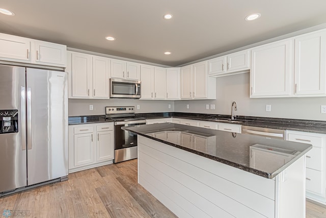 kitchen featuring sink, white cabinets, light hardwood / wood-style flooring, and appliances with stainless steel finishes