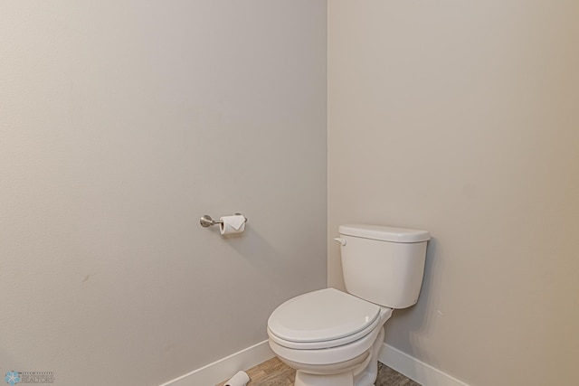 bathroom with hardwood / wood-style floors and toilet