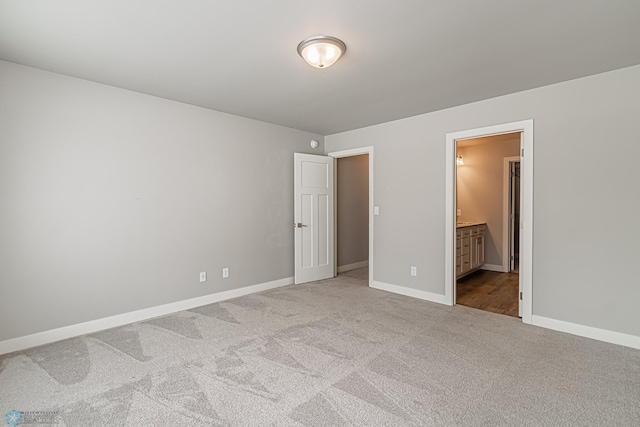 unfurnished bedroom featuring carpet and ensuite bath