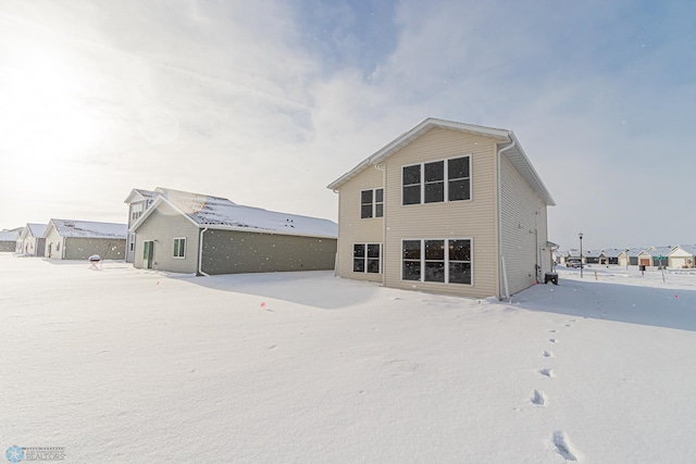 view of snow covered back of property