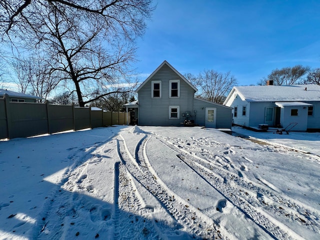 view of snow covered rear of property