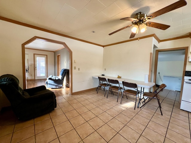 tiled dining area featuring ceiling fan and crown molding