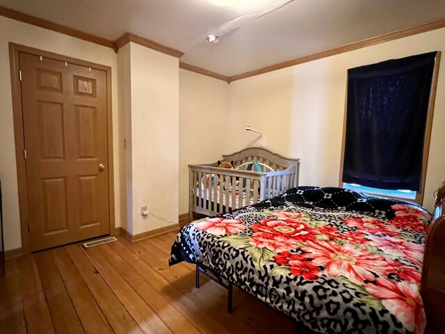 bedroom featuring hardwood / wood-style flooring and ornamental molding