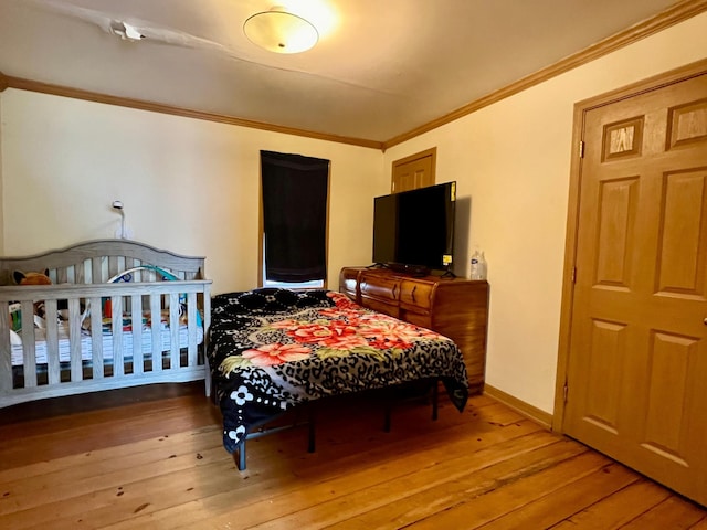 bedroom with hardwood / wood-style floors and ornamental molding