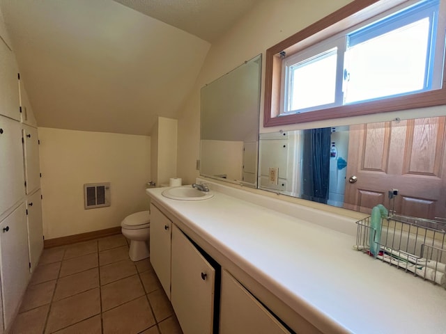 bathroom with tile patterned flooring, vanity, toilet, and lofted ceiling