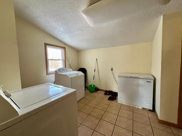 laundry area with light tile patterned floors, a textured ceiling, and separate washer and dryer