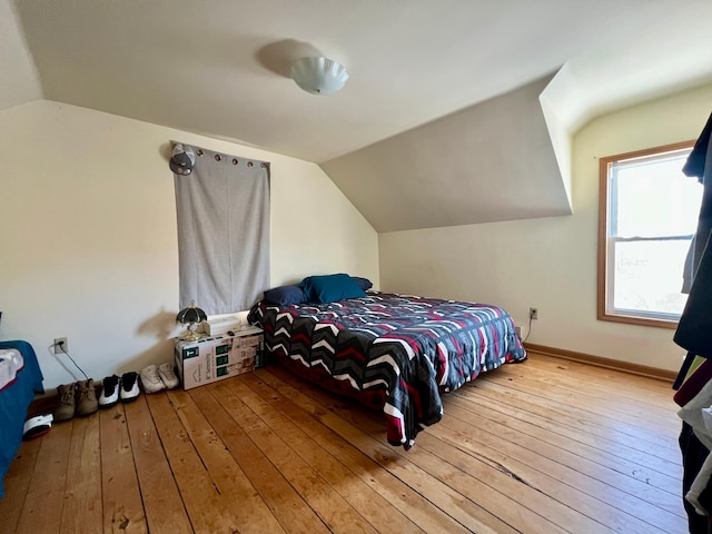 bedroom featuring light hardwood / wood-style flooring and lofted ceiling