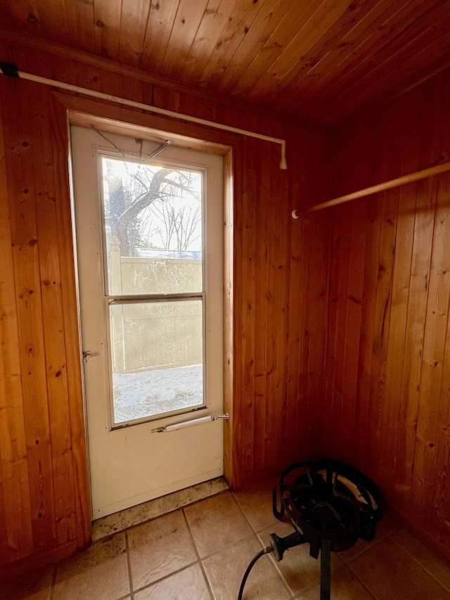 doorway to outside featuring wood walls, tile patterned flooring, and wooden ceiling