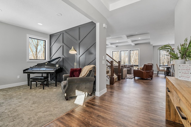 living area with dark wood-type flooring, beamed ceiling, a healthy amount of sunlight, and coffered ceiling