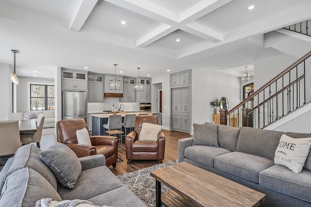 living room featuring dark hardwood / wood-style floors, beam ceiling, sink, and coffered ceiling