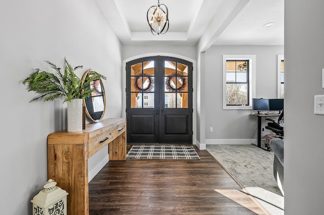 foyer entrance featuring a chandelier, french doors, and dark wood-type flooring