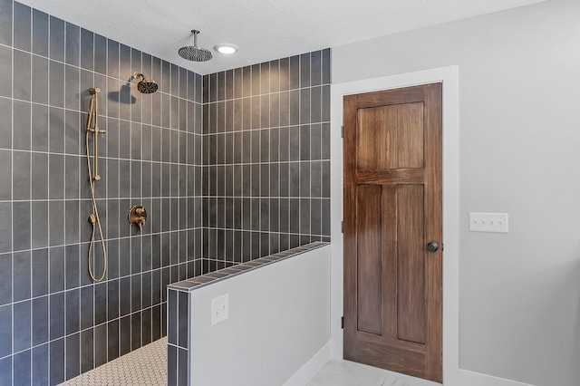 bathroom featuring a tile shower and a textured ceiling