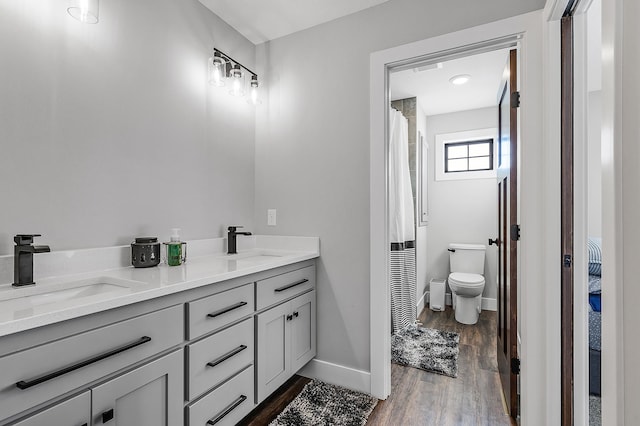 bathroom featuring vanity, hardwood / wood-style flooring, toilet, and curtained shower