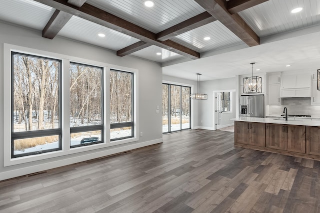 kitchen featuring white cabinets, stainless steel fridge, a wealth of natural light, and pendant lighting