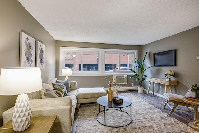 living room featuring hardwood / wood-style floors, a textured ceiling, and baseboard heating