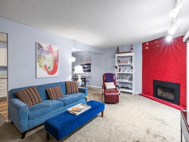 living room with carpet flooring, a textured ceiling, track lighting, and a brick fireplace