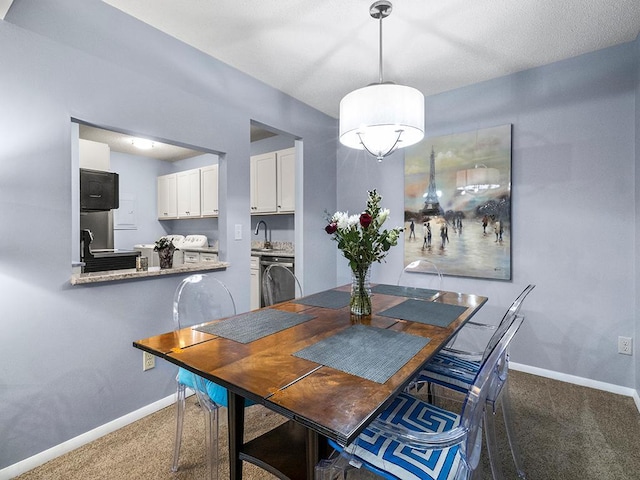 dining space with carpet floors and sink