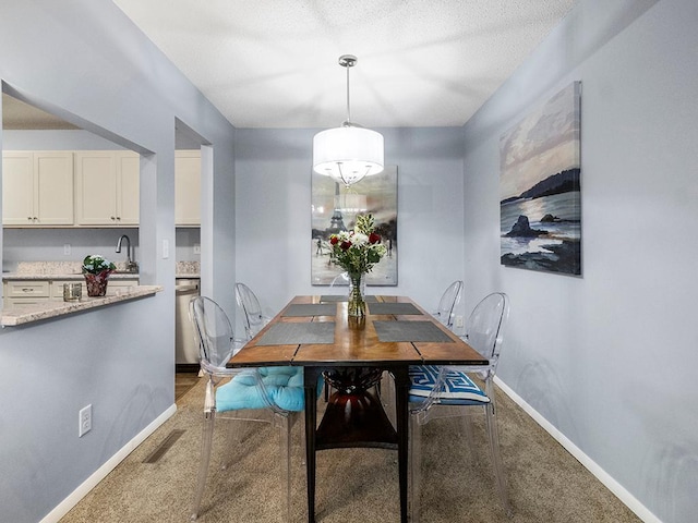 dining room featuring carpet flooring, a textured ceiling, and sink