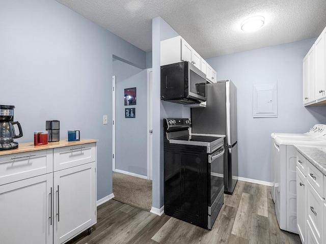 kitchen featuring washing machine and dryer, white cabinets, stainless steel appliances, and a textured ceiling