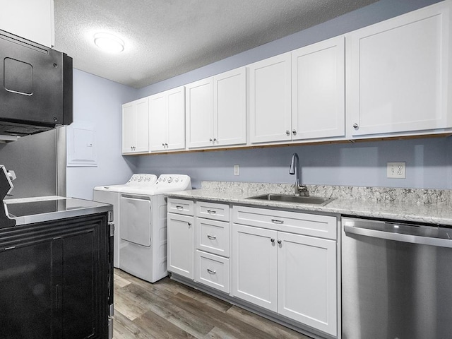 laundry area featuring a textured ceiling, sink, dark wood-type flooring, and washing machine and clothes dryer