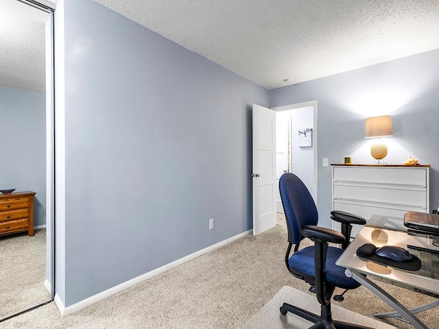 office area with a textured ceiling and light colored carpet