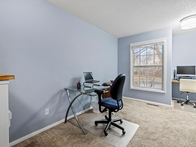 carpeted office space with a textured ceiling