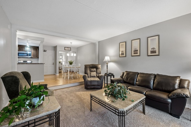 carpeted living room featuring an inviting chandelier and a textured ceiling