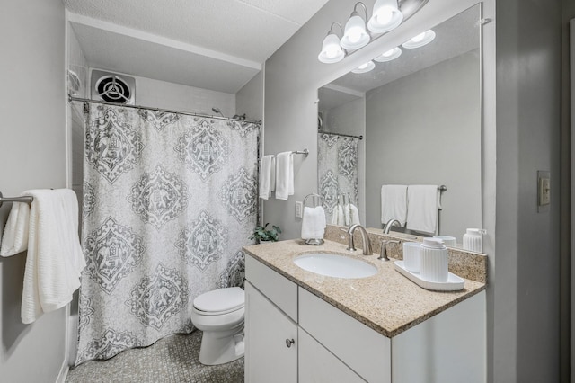 bathroom with vanity, a textured ceiling, and toilet