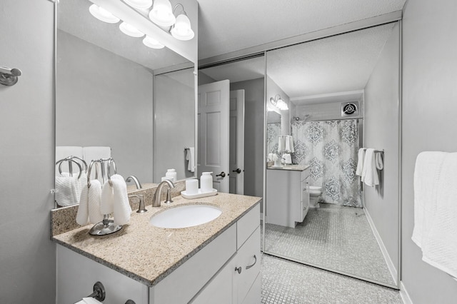 bathroom featuring tile patterned flooring, vanity, toilet, and walk in shower