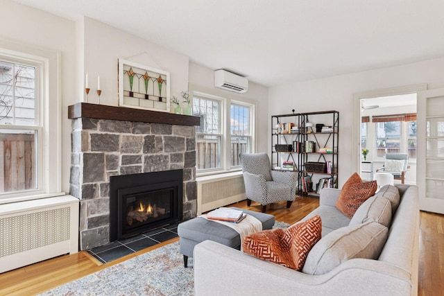 living room featuring radiator heating unit, a wall unit AC, and wood finished floors